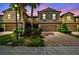 Townhome showcasing a well-manicured lawn, colorful landscaping, and a brick driveway at 28568 Tranquil Lake Cir, Wesley Chapel, FL 33543