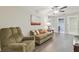 Comfortable living room featuring a sofa and a recliner, with natural light at 28568 Tranquil Lake Cir, Wesley Chapel, FL 33543