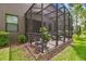 Charming screened patio with a table and chairs, great for outdoor dining at 28568 Tranquil Lake Cir, Wesley Chapel, FL 33543