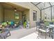 Relaxing covered patio featuring a ceiling fan, comfortable seating, and an outdoor dining area at 28568 Tranquil Lake Cir, Wesley Chapel, FL 33543