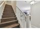 Staircase with wood flooring and white railing offers a view into the kitchen and dining area at 28568 Tranquil Lake Cir, Wesley Chapel, FL 33543