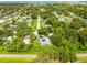An aerial shot of a community surrounded by lots of trees, and a house with solar panels on its roof at 321 Barbara Cir, Belleair, FL 33756