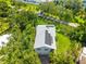 Aerial view of a charming home with solar panels, lush landscaping and a brick driveway at 321 Barbara Cir, Belleair, FL 33756