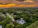 Breathtaking sunset view of the home and lush surroundings of the area and the city skyline in the background at 321 Barbara Cir, Belleair, FL 33756