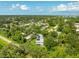 An aerial view of a house with solar panels surrounded by greenery, near the waterfront at 321 Barbara Cir, Belleair, FL 33756
