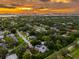 Stunning aerial view of the property with a sunset sky, highlighting its proximity to the city and the water at 321 Barbara Cir, Belleair, FL 33756