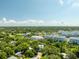 Overhead shot of a neighborhood with apartments, homes, and lush trees under a bright sky at 321 Barbara Cir, Belleair, FL 33756