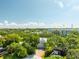 An aerial view of a two-story home with mature trees and lush landscaping at 321 Barbara Cir, Belleair, FL 33756