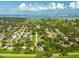 Expansive aerial view of a lush, green residential area near a golf course and the ocean, showcasing a desirable coastal community at 321 Barbara Cir, Belleair, FL 33756