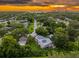 Sunset aerial view of neighborhood homes with solar panels against a fiery sky at 321 Barbara Cir, Belleair, FL 33756
