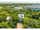 Aerial view of a residence featuring solar panels on the roof, surrounded by mature trees at 321 Barbara Cir, Belleair, FL 33756
