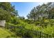 This home features a tranquil backyard with black metal fence and lush greenery at 321 Barbara Cir, Belleair, FL 33756