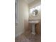 Charming powder room showcasing a pedestal sink, decorative mirror, and tiled flooring at 321 Barbara Cir, Belleair, FL 33756