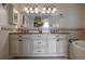 Bright bathroom vanity with dual sinks, a granite countertop, decorative mirrors and updated fixtures provide modern elegance at 321 Barbara Cir, Belleair, FL 33756