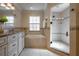 Bathroom features a double sink vanity, soaking tub, and walk-in shower with decorative tile and updated fixtures at 321 Barbara Cir, Belleair, FL 33756