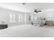 This primary bedroom features plush carpet, tray ceiling, modern ceiling fan and plantation shutters at 321 Barbara Cir, Belleair, FL 33756