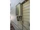 Exterior water heater on wall of house with grey siding and attached piping; view of home's infrastructure at 321 Barbara Cir, Belleair, FL 33756
