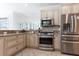 Modern kitchen with stainless steel appliances, granite countertops, tile backsplash, and custom cabinets at 321 Barbara Cir, Belleair, FL 33756