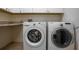 Modern laundry room featuring front load washer and dryer with upper cabinets and ample counter space at 321 Barbara Cir, Belleair, FL 33756
