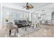 Spacious living room with tile floors, plantation shutters, ceiling fan, and neutral furniture next to dining area at 321 Barbara Cir, Belleair, FL 33756