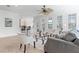 Open-concept living room with tile floors, a ceiling fan, and comfortable seating adjacent to kitchen and dining area at 321 Barbara Cir, Belleair, FL 33756