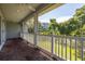 Brick floored covered porch with white railings and a yard view at 321 Barbara Cir, Belleair, FL 33756