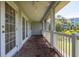 Brick floored covered porch with white railings and french doors at 321 Barbara Cir, Belleair, FL 33756