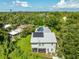 This is an aerial of the rear exterior with a screened porch and showing solar panels on the roof of the home at 321 Barbara Cir, Belleair, FL 33756