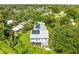 Aerial view of a home with solar panels on the roof and a lush backyard at 321 Barbara Cir, Belleair, FL 33756