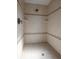 Tiled shower with a showerhead and built-in shelves providing a clean and functional space at 321 Barbara Cir, Belleair, FL 33756
