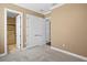 Bedroom with carpet, featuring double doors, and view to a bathroom with a tiled shower, providing a private retreat at 3214 Forsythia Dr, Odessa, FL 33556