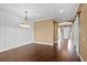Dining room with dark wood floors, decorative chandelier, accent wall, and view to the front entry at 3214 Forsythia Dr, Odessa, FL 33556