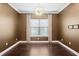 A dining room with hardwood floors, a large window with blinds and curtains, and a modern chandelier overhead at 3214 Forsythia Dr, Odessa, FL 33556