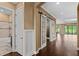 Entryway features rich wood floors, barn doors, and views of a luxurious bathroom and backyard at 3214 Forsythia Dr, Odessa, FL 33556