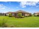 Landscaped backyard featuring a well-maintained lawn and a glimpse of the property's exterior architecture at 3214 Forsythia Dr, Odessa, FL 33556