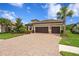 Beautiful single-story home with a paver driveway, lush landscaping and a two-car garage at 3214 Forsythia Dr, Odessa, FL 33556