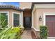Elegant front entry with a black door framed by manicured landscaping and a brick walkway at 3214 Forsythia Dr, Odessa, FL 33556