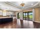 Open kitchen with a large center island, designer lighting and backyard views through sliding glass doors at 3214 Forsythia Dr, Odessa, FL 33556