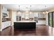 Bright, expansive kitchen featuring a large black island with seating, modern fixtures, and stainless appliances at 3214 Forsythia Dr, Odessa, FL 33556