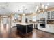Open kitchen features a large island, stainless appliances, pendant lights, and hardwood flooring at 3214 Forsythia Dr, Odessa, FL 33556