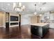 Open concept living room and kitchen with fireplace, built-ins, large island and hardwood floors at 3214 Forsythia Dr, Odessa, FL 33556