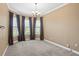 Versatile room showcasing carpet, large windows with dark curtains, and a corner nook, perfect for a sitting area at 3214 Forsythia Dr, Odessa, FL 33556
