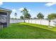 Spacious backyard featuring lush green lawn and white vinyl fencing perfect for outdoor activities at 33854 Floating Heart Ct, Wesley Chapel, FL 33545
