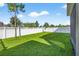 Spacious backyard featuring lush green lawn and white vinyl fencing perfect for outdoor activities at 33854 Floating Heart Ct, Wesley Chapel, FL 33545