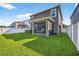 Picture of a spacious backyard featuring lush green lawn, screened lanai, and white vinyl fencing at 33854 Floating Heart Ct, Wesley Chapel, FL 33545