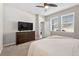 Inviting bedroom with a queen bed, dresser with TV, and bright windows at 33854 Floating Heart Ct, Wesley Chapel, FL 33545