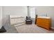 Charming Bedroom with a crib, glider chair, dresser, and window bringing in plenty of natural light at 33854 Floating Heart Ct, Wesley Chapel, FL 33545