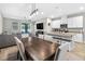 Open-concept dining area with modern light fixture, neutral decor, and seamless flow to kitchen and living spaces at 33854 Floating Heart Ct, Wesley Chapel, FL 33545