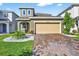 Inviting two-story home featuring manicured lawn and a tan two car garage at 33854 Floating Heart Ct, Wesley Chapel, FL 33545