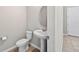 Neutral powder room with pedestal sink, oval mirror, and tiled flooring at 33854 Floating Heart Ct, Wesley Chapel, FL 33545